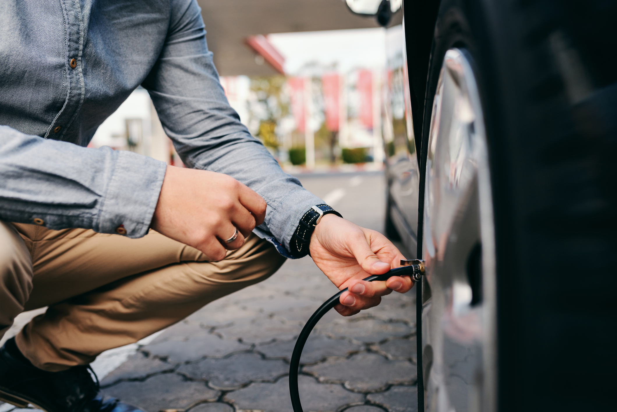 Man putting air in vehicle tire